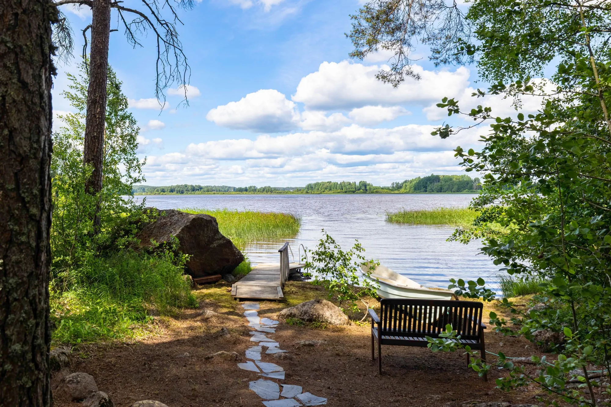 Hirsimökki metsäisessä pihapiirissä